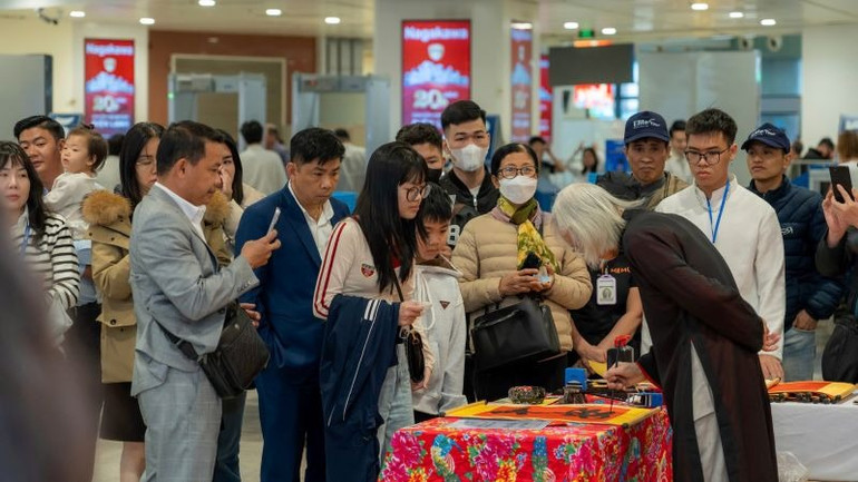 Thầy đồ viết và tặng chữ thư pháp như lời chúc may mắn đầu năm.