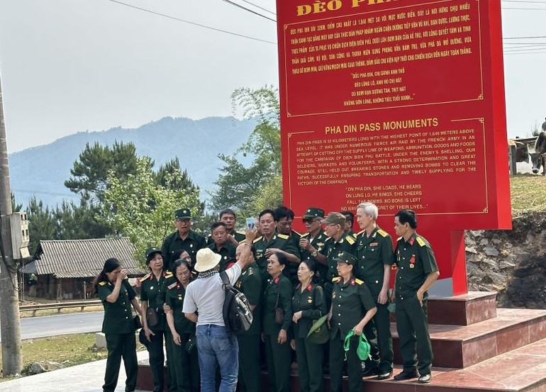 Bên tấm bia di tích đèo Pha Đin, từng đoàn cựu chiến binh, thanh niên xung phong về thăm chiến trường Điện Biên dừng lại chụp ảnh kỷ niệm.