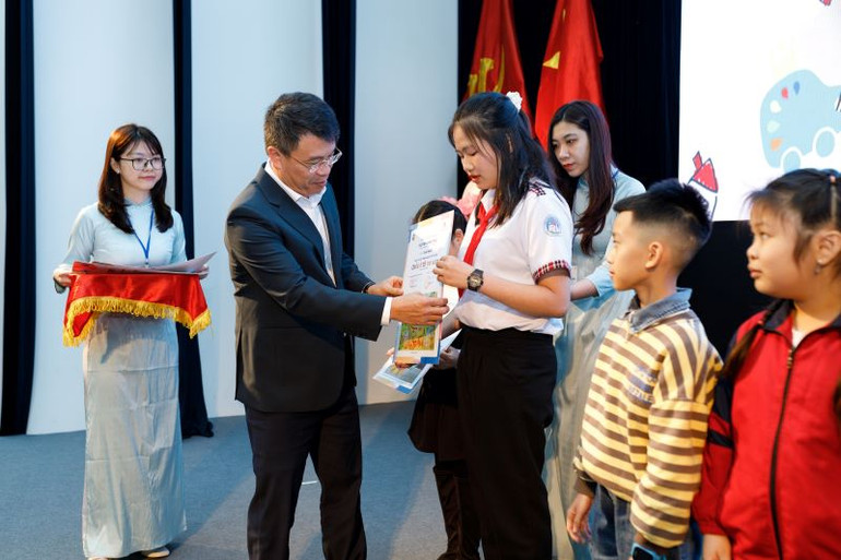 Tổng Biên tập Báo Thiếu niên Tiền phong và Nhi đồng trao giải Nhất năm 2022 cho các em học sinh.