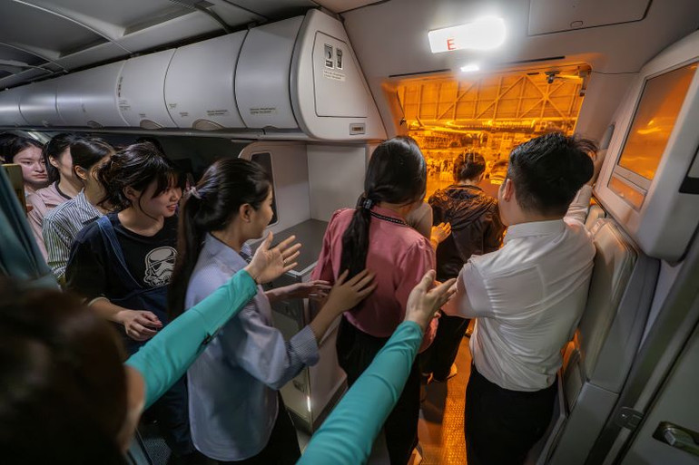 Tổ tiếp viên mở cửa và hướng dẫn hành khách thoát hiểm trên máy bay.