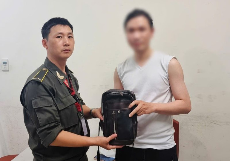 Anh Nguyễn Sỹ Đàn, nhân viên An ninh cơ động- Trung tâm An ninh hàng không Nội Bài trao trả chiếc ví bỏ quên chứa 250 ngàn yên Nhật cho nam hành khách.