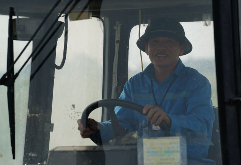 Nụ cười của nhân viên lái xe Đội Môi trường sân bay trong nắng nóng gay gắt.