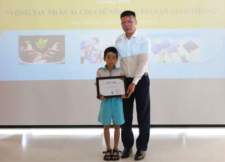 Đại diện Đại lý Toyota Huế trao tặng học bổng cho một em học sinh.