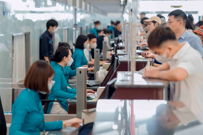 Nhân viên hãng hàng không Vietnam Airlines làm thủ tục hàng không cho hành khách.