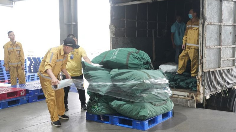 Nhân viên kho hàng dỡ các thùng hàng cứu trợ từ xe tải xuống, bảo đảm rằng mọi thứ được xử lý một cách nhanh chóng và chính xác.