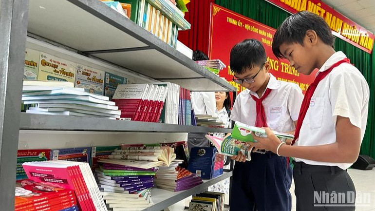 Các em học sinh trường Trung học cơ sở Lê Hồng Phong bên những bộ sách mới được tặng