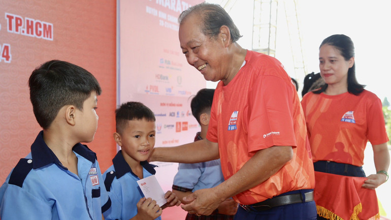 Nguyên Phó Thủ tướng Thường trực Chính phủ Trương Hoà Bình trao học bổng cho các em học sinh.