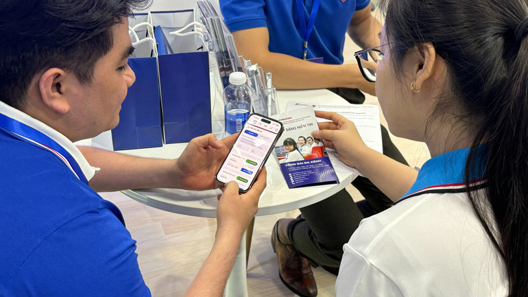 Nhân viên chăm sóc khách hàng ngành điện Thành phố Hồ Chí Minh hướng dẫn khách hàng thanh toán tiền điện trên điện thoại di động.