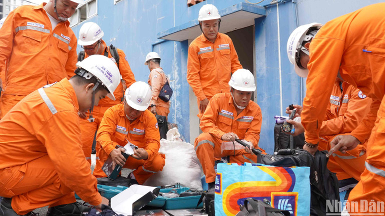 Các công nhân chuẩn bị thiết bị, dụng cụ trước giờ lên đường.