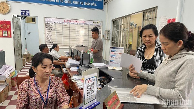 Công chức, viên chức Ủy ban nhân dân phường 4 (quận Gò Vấp) hướng dẫn người dân thực hiện thủ tục hành chính sáng 15/2.