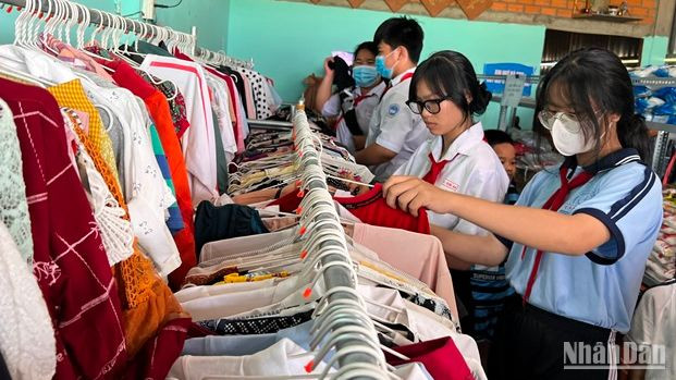 Các em học sinh lựa quần áo tại cửa hàng 0 đồng