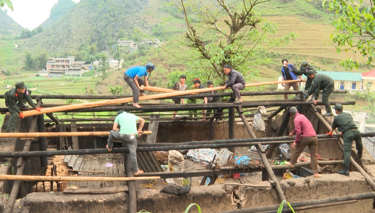 Các chiến sĩ cảnh sát cơ động giúp người dân lợp lại mái nhà bị hư hỏng do mưa đá.