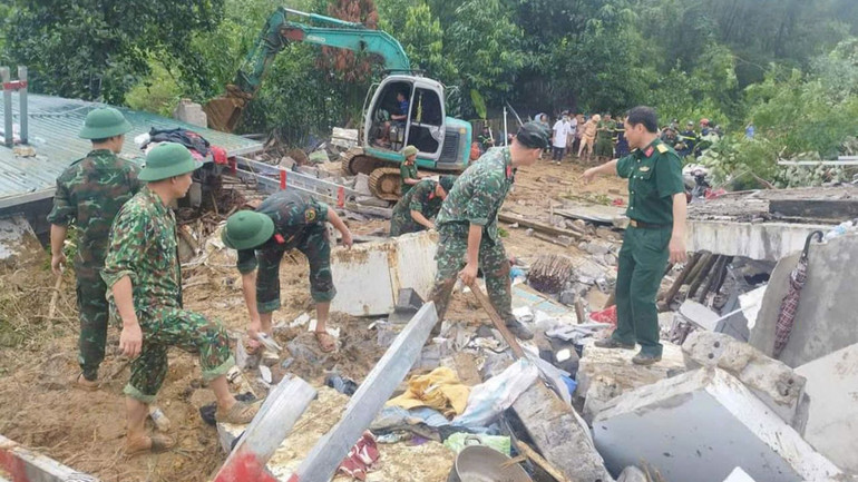 Lực lượng chức năng hỗ trợ người dân khắc phục hậu quả do sạt lở đất.