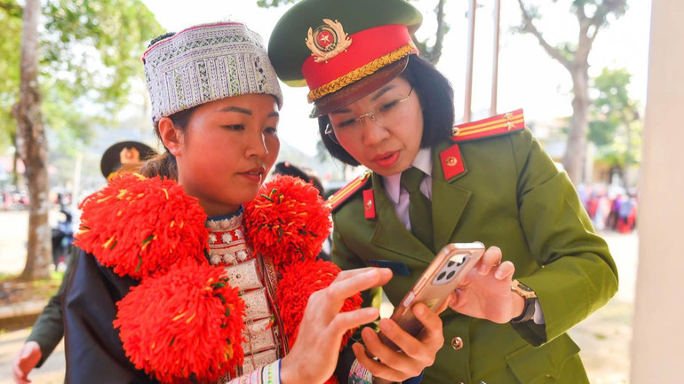 Phụ nữ Công an tỉnh Hà Giang hướng dẫn người dân quét mã QR phổ biến giáo dục pháp luật. (Ảnh: KHÁNH LINH)