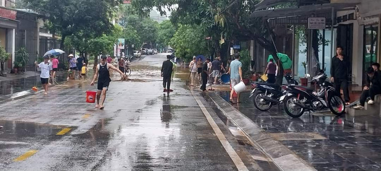 Người dân thành phố Hà Giang vệ sinh đường phố sau khi nước rút.