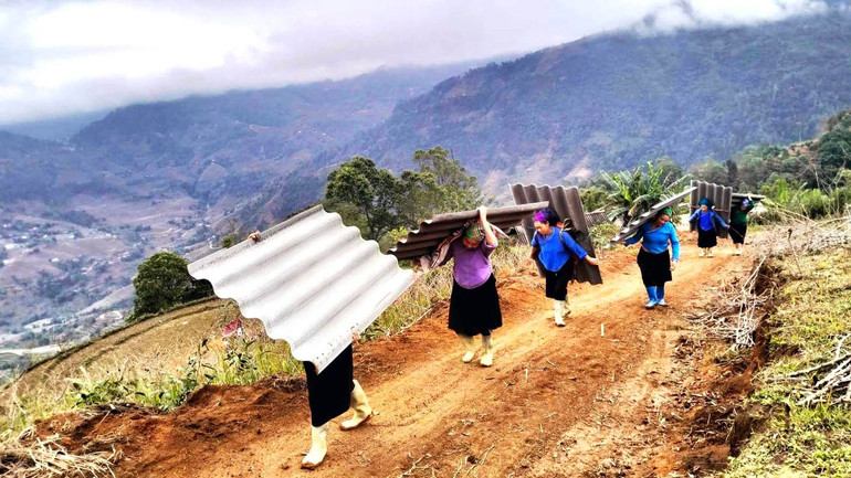 Hội viên phụ nữ tỉnh Hà Giang giúp công lao động vận chuyển vật liệu xóa nhà tạm cho hộ nghèo.