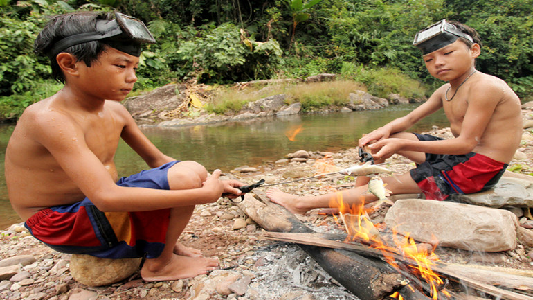 Học sinh đi lấy củi, đi bắt cá cải thiện bữa ăn sau giờ học cũng chẳng hiếm đối với những bản vùng khó cách đây hơn chục năm (Trong ảnh: Học sinh Trường Nậm Ngà, xã Tà Tổng bắt cá cải thiện cuộc sống sau giờ học).