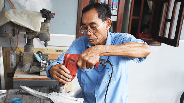 Cựu quân nhân Bùi Xuân Thành miệt mài chế tác mô hình chiến đấu cơ.