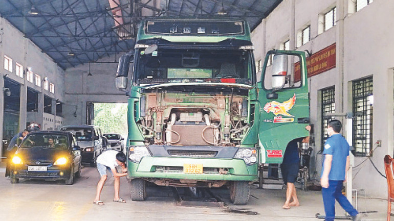 Cán bộ Trung tâm Kiểm định kỹ thuật phương tiện, thiết bị giao thông cơ giới kiểm định xe ô-tô cho khách hàng. (Ảnh Minh Linh)