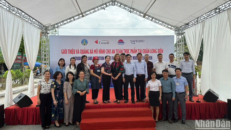 Các đại biểu chụp ảnh tại sự kiện quảng bá và giới thiệu mô hình chợ an toàn thực phẩm (ATTP) tại quận Long Biên.