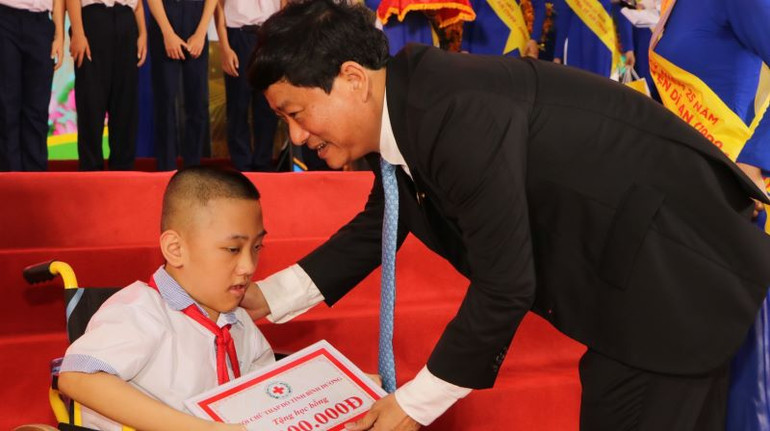Chủ tịch Ủy ban nhân dân tỉnh Bình Dương Võ Văn Minh trao học bổng cho học sinh có hoàn cảnh khó khăn.