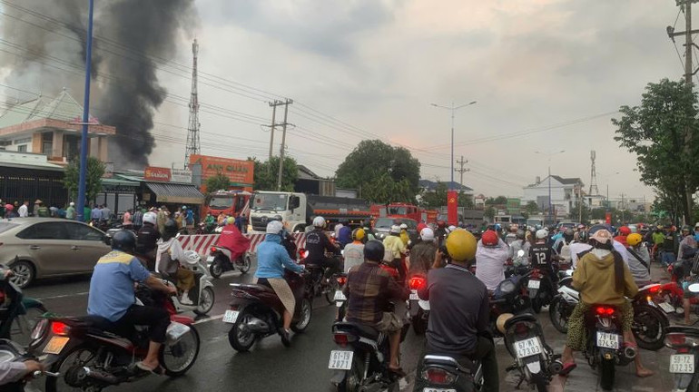 Người đi đường hiếu kỳ dừng xe đứng xem vụ cháy.