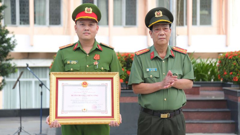 Đại tá Nguyễn Văn Dựt, Phó Giám đốc Công an tỉnh Bình Dương trao tặng Huân chương chiến công hạng Ba cho Thiếu tá Võ Văn Sơn.
