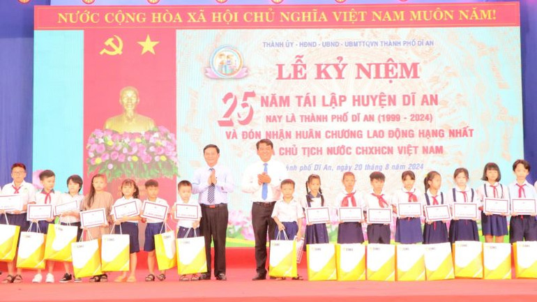 Lãnh đạo Hội đồng nhân dân tỉnh và lãnh đạo Ban Dân vận Tỉnh ủy Bình Dương trao học bổng và quà cho học sinh có hoàn cảnh khó khăn.