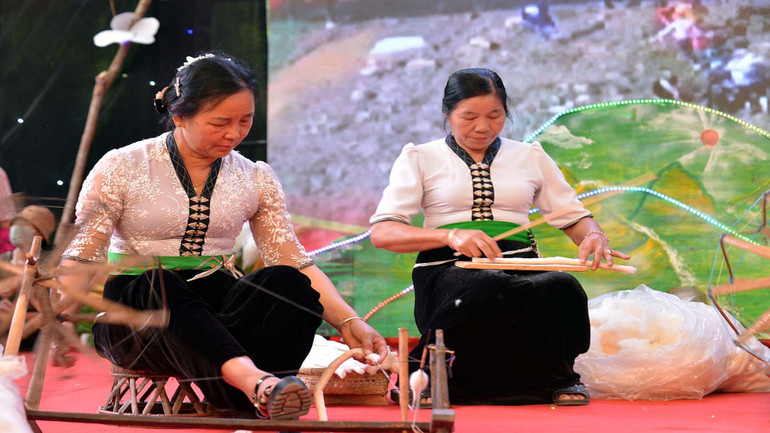 Nếu đàn ông giỏi chài lưới, bắt cá và lo những việc nặng trong nhà... thì phụ nữ người Thái lại giỏi quay tơ dệt vải, đảm đang trong việc bếp núc, chăm sóc gia đình. (Trong ảnh: Thi quay sợi.)