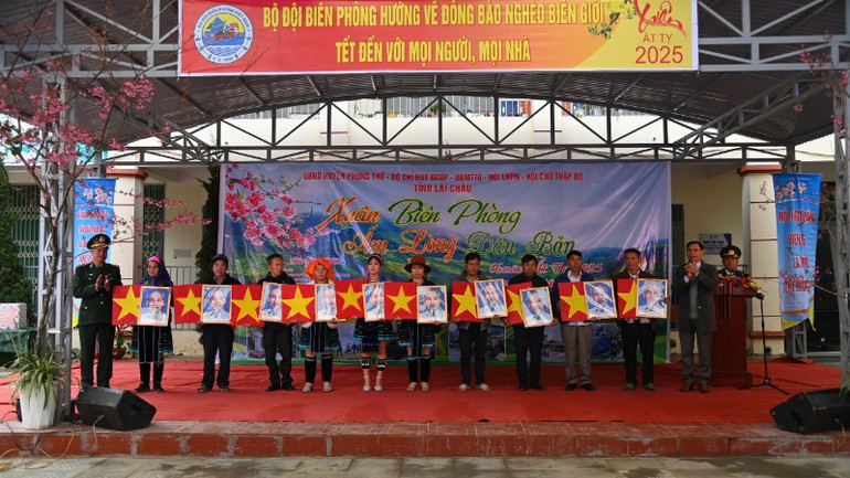 Tặng cờ Tổ quốc và ảnh Bác Hồ cho các hộ gia đình ở biên giới.