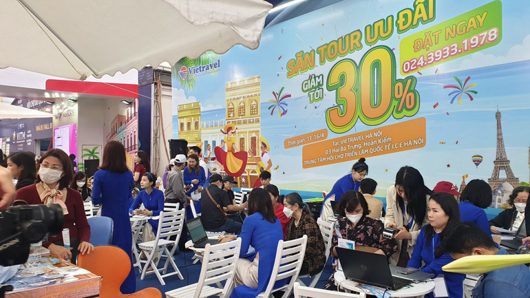 Du khách tham khảo giá tour khuyến mãi tại gian hàng của Vietravel. (Ảnh: T.LINH)