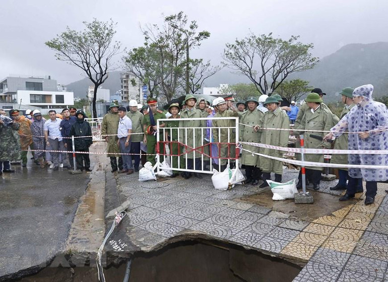 Hình ảnh Chủ tịch nước Nguyễn Xuân Phúc và đoàn kiểm tra thực địa công tác khắc phục thiệt hại các công trình hạ tầng tại điểm sạt cuối đường Lê Văn Lương, Hoàng Sa, phường Thọ Quang, quận Sơn Trà. (Ảnh: Thống Nhất/TTXVN)