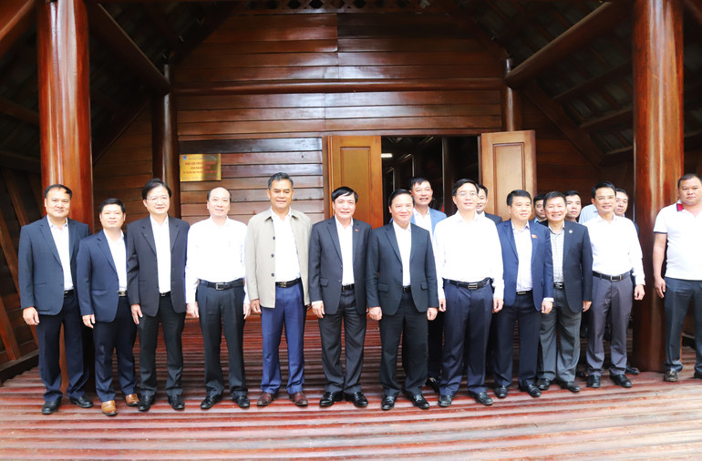 Phó Chủ tịch Quốc hội Nguyễn Khắc Định cùng các đại biểu chụp hình lưu niệm tại Nhà dài truyền thống của người Ê đê.