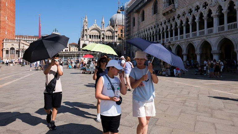 Khách du lịch đi bộ trong đợt nắng nóng đỉnh điểm ở Venice, Italia ngày 22/8/2023. (Ảnh: REUTERS) Khách du lịch đi bộ trong đợt nắng nóng đỉnh điểm ở Venice, Italia ngày 22/8/2023. (Ảnh: REUTERS)