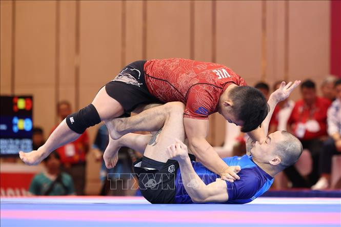 Đào Hồng Sơn (áo đỏ) và thắng Tang Yong Siang (Singapore, áo xanh) nội dung đối kháng Ne-Waza Nogi nam - hạng 56kg, giành Huy chương Vàng (Ảnh: TTXVN)