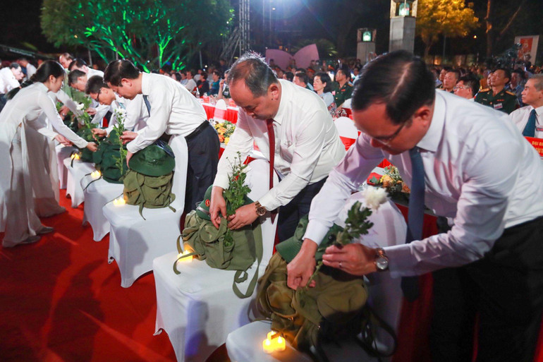 Những đoá hoa cúc và nến được đặt bên cạnh những chiếc ba lô, tưởng niệm các liệt sĩ đã hy sinh vì Tổ quốc. (Ảnh: DUY LINH)