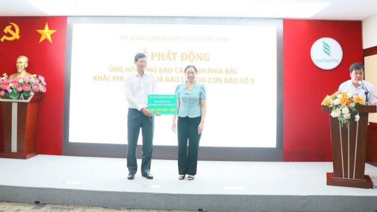 Lãnh đạo Công ty Trách nhiệm hữu hạn Một thành viên Tổng Công ty cao-su Đồng Nai trao biểu trưng ủng hộ 300 triệu đồng.