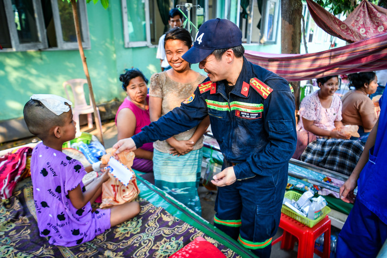 Đại tá Nguyễn Minh Khương thăm hỏi, tặng quà và tiền mặt cho một bệnh nhân bị thương do động đất tại bệnh viện.