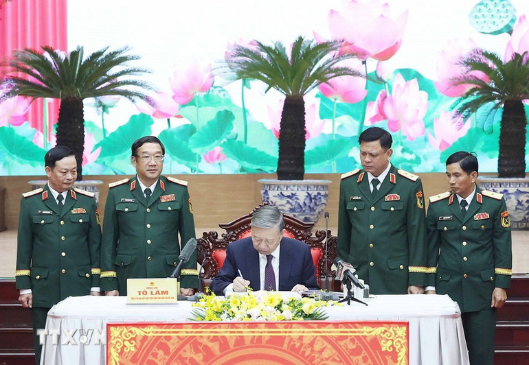 Tổng Bí thư Tô Lâm , Bí thư Quân uỷ Trung ương ghi sổ vàng lưu niệm. Ảnh: Thống Nhất/TTXVN