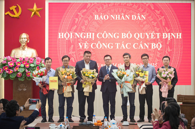 Đồng chí Lê Quốc Minh, Ủy viên Trung ương Đảng, Tổng Biên tập Báo Nhân Dân trao quyết định công tác cán bộ cho các đồng chí lãnh đạo Ban Nhân Dân điện tử. (Ảnh: SƠN TÙNG)