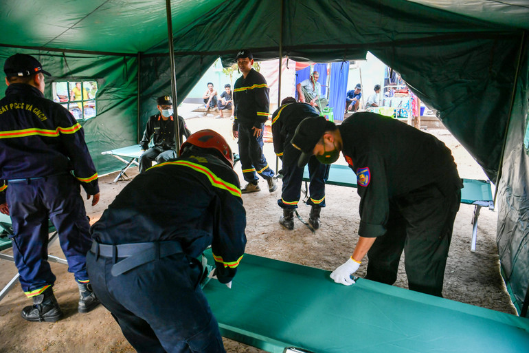 Cán bộ, chiến sĩ đoàn cứu hộ, cứu nạn Bộ Công an lắp đặt lều dã chiến và hệ thống giường tạm cho các bệnh nhân đang điều trị tại bệnh viện.