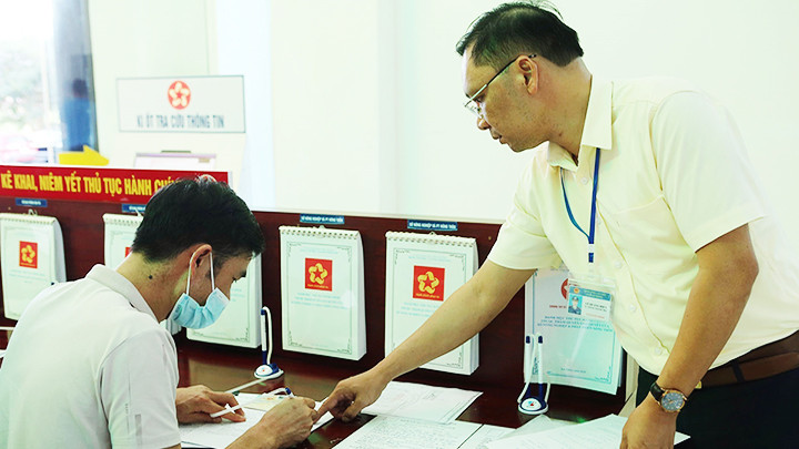 Cán bộ Sở Giao thông vận tải Lai Châu hướng dẫn người dân kê khai thủ tục làm các loại giấy tờ liên quan. Ảnh: TTXVN