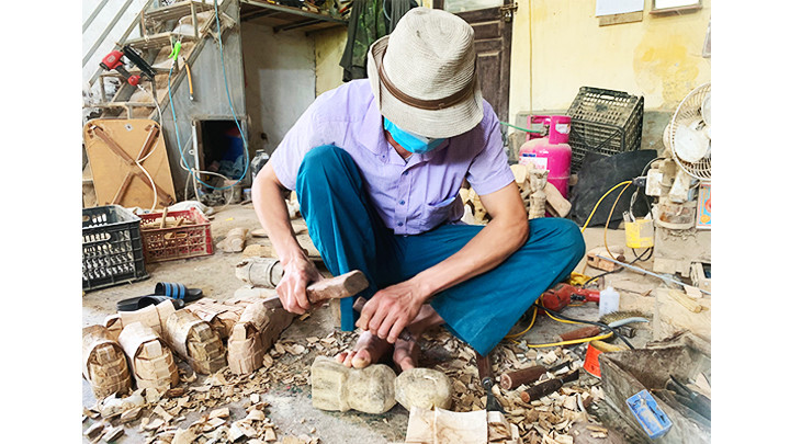 Anh Phan Văn Chăm tỉ mỉ tạo hình con rối.
