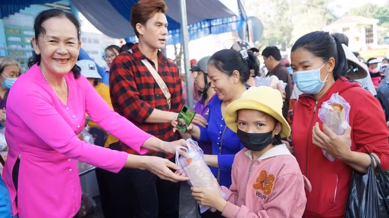 Phát bánh mì miễn phí cho khách đến lễ hội.