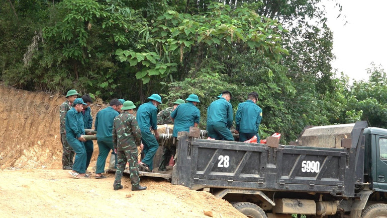 Lực lượng dân quân xã Lang Thíp di chuyển bom lên xe. (Ảnh: THANH SƠN)