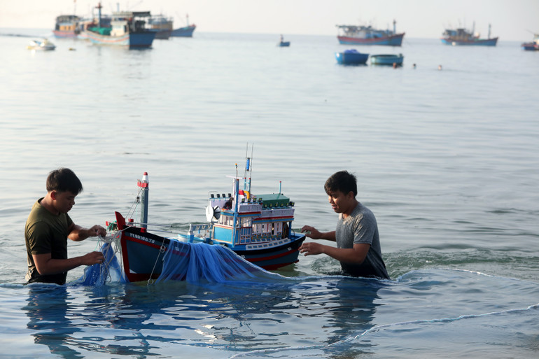 Ngư dân trẻ thực hành thả lưới bằng mô hình tàu biển.
