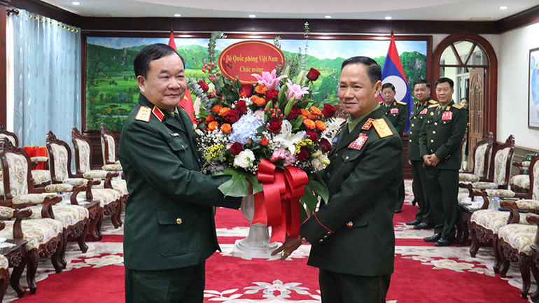 Thượng tướng Hoàng Xuân Chiến trao lẵng hoa tươi thắm chúc mừng nhân dịp kỷ niệm 76 năm ngày thành lập Quân đội nhân dân Lào (20/1/1949-20/1/2025). (Ảnh: TRỊNH DŨNG)