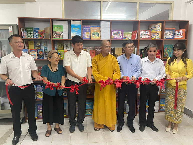 Các đại biểu cắt băng khai trương tủ sách tiếng Việt miễn phí. (Ảnh: HẢI TIẾN)