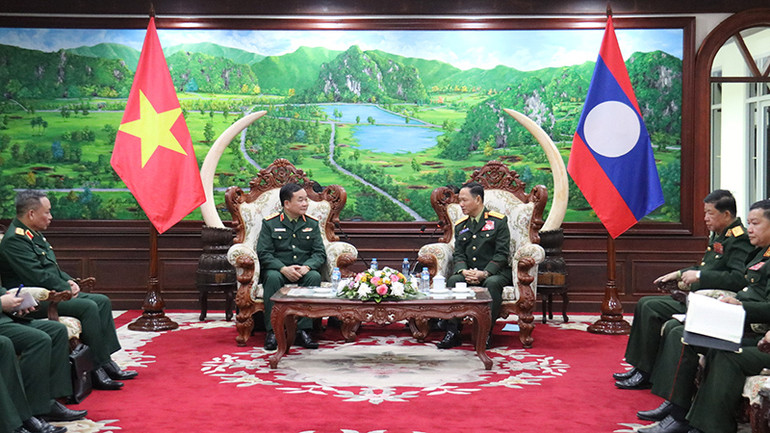Thượng tướng Hoàng Xuân Chiến trao đổi với Bộ trưởng Quốc phòng Lào. (Ảnh: TRỊNH DŨNG)