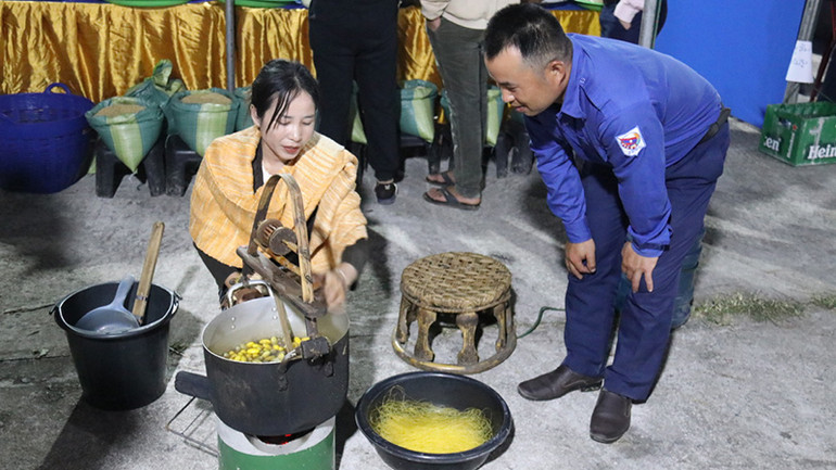 Thiếu nữ Lào kéo sợi tơ tằm tại Hội chợ. (Ảnh: Hải Tiến)
